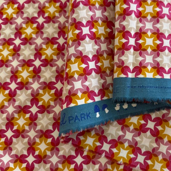 Woodland Park By Rashida Coleman-Hale geometric star cotton fabric in pink, mustard, and beige tones
