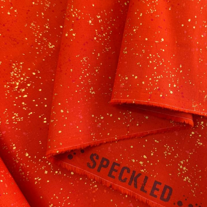 Ruby Star Society Speckled metallic cotton fabric available in navy, pink, and orange colors.