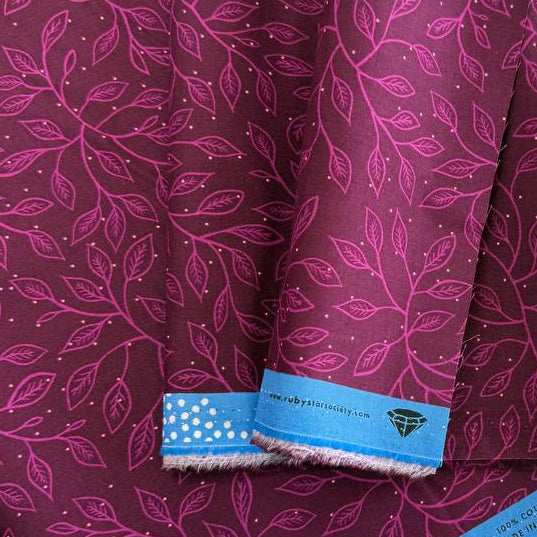 Glow Garden cotton fabric by Sarah Watts for Ruby Star Society with delicate vine leaf pattern in pink and blue colorways on dark backgrounds