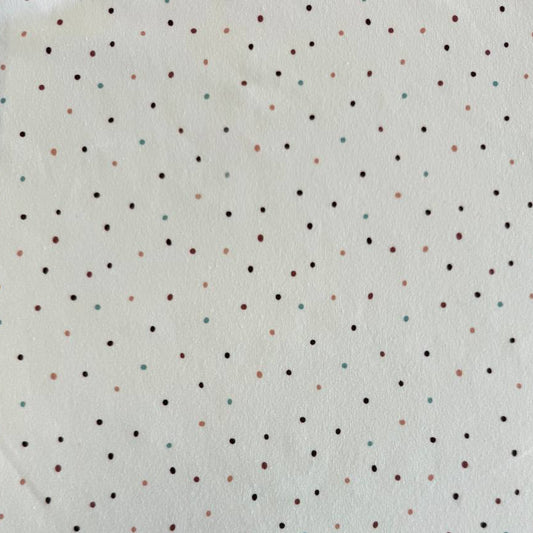 White cotton jersey knit fabric with small multicolor dot print and soft stretch texture.