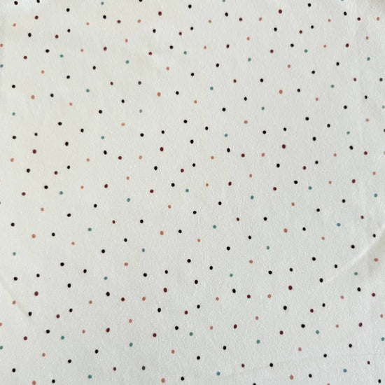 White cotton jersey knit fabric with small multicolor dot print and soft stretch texture.