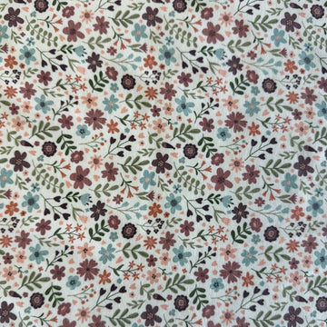 Noote floral cotton jersey fabric with dusty pink, mauve, sage, and blue flowers on an ivory background.