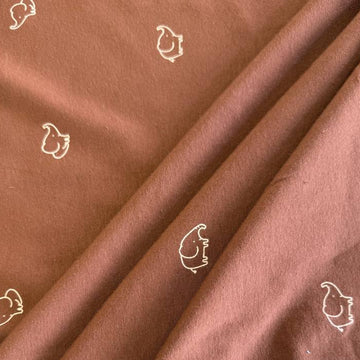 Brown cotton jersey knit fabric with small white elephant print.