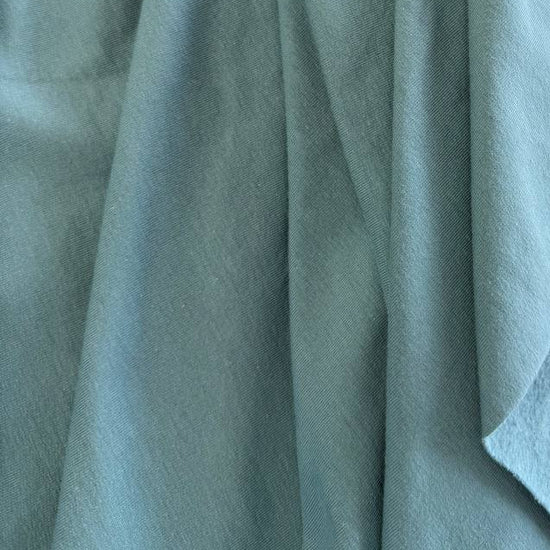 Dusty mint brushed French terry fabric draped close-up