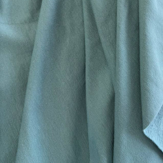 Dusty mint brushed French terry fabric draped close-up
