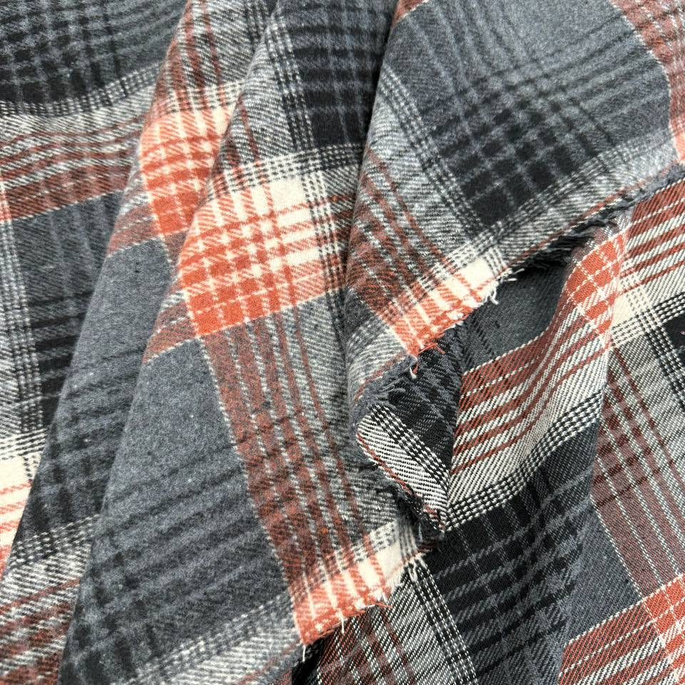 Black, grey, cream and rust double-sided plaid fabric with a classic yarn-dyed tartan pattern.