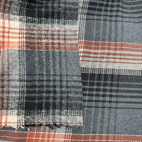 Black, grey, cream and rust double-sided plaid fabric with a classic yarn-dyed tartan pattern.