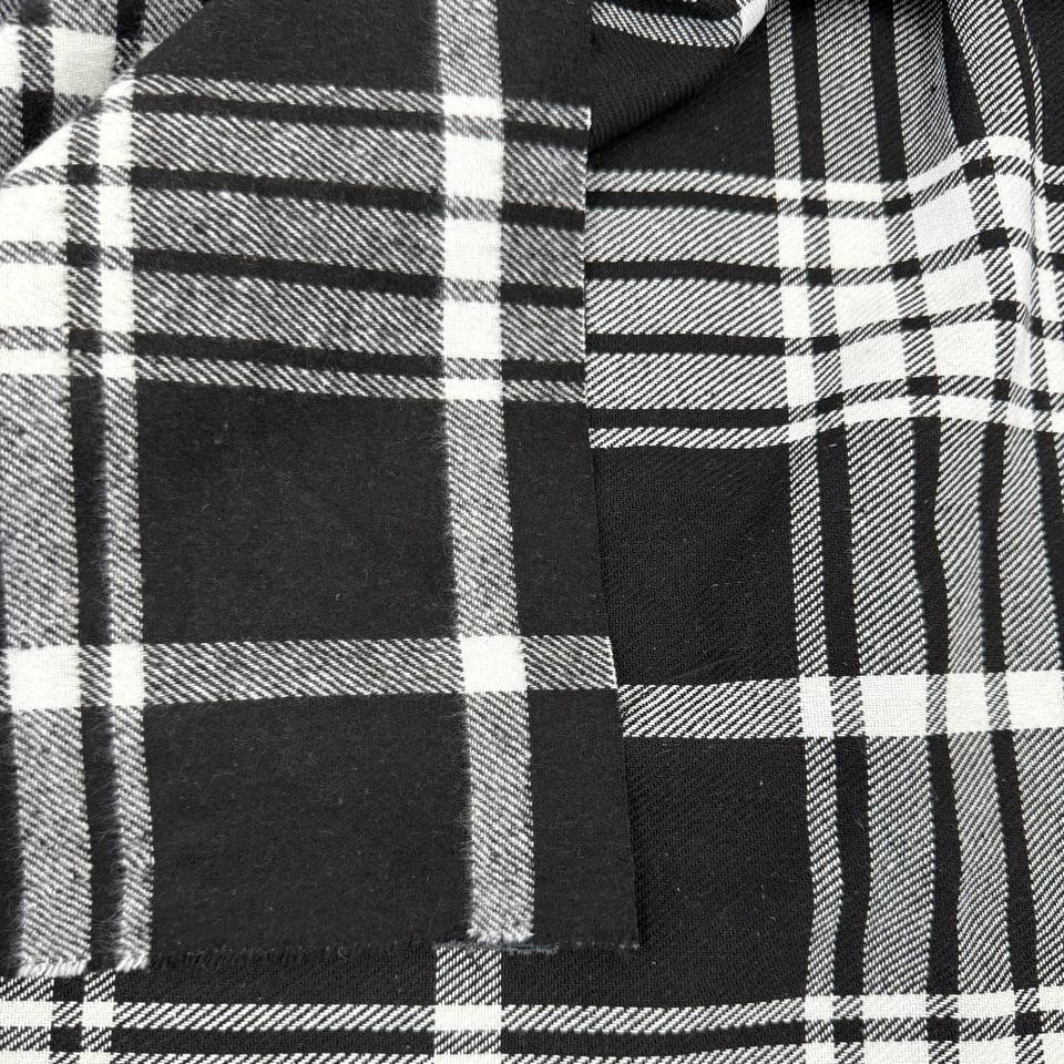 Black and white double-sided yarn-dyed plaid fabric with a classic tartan pattern.