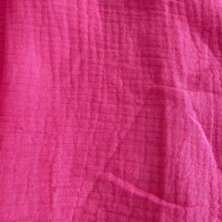 Bright and beautiful double gauze fabric in a vibrant pink shade.