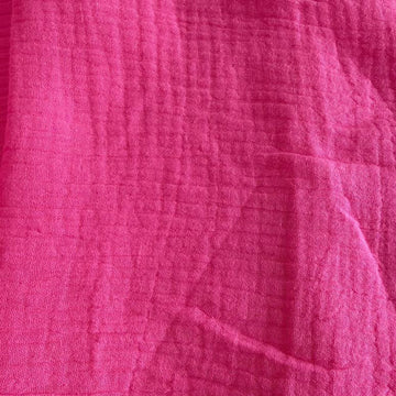 Bright and beautiful double gauze fabric in a vibrant pink shade.
