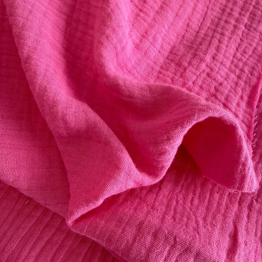Bright and beautiful double gauze fabric in a vibrant pink shade.