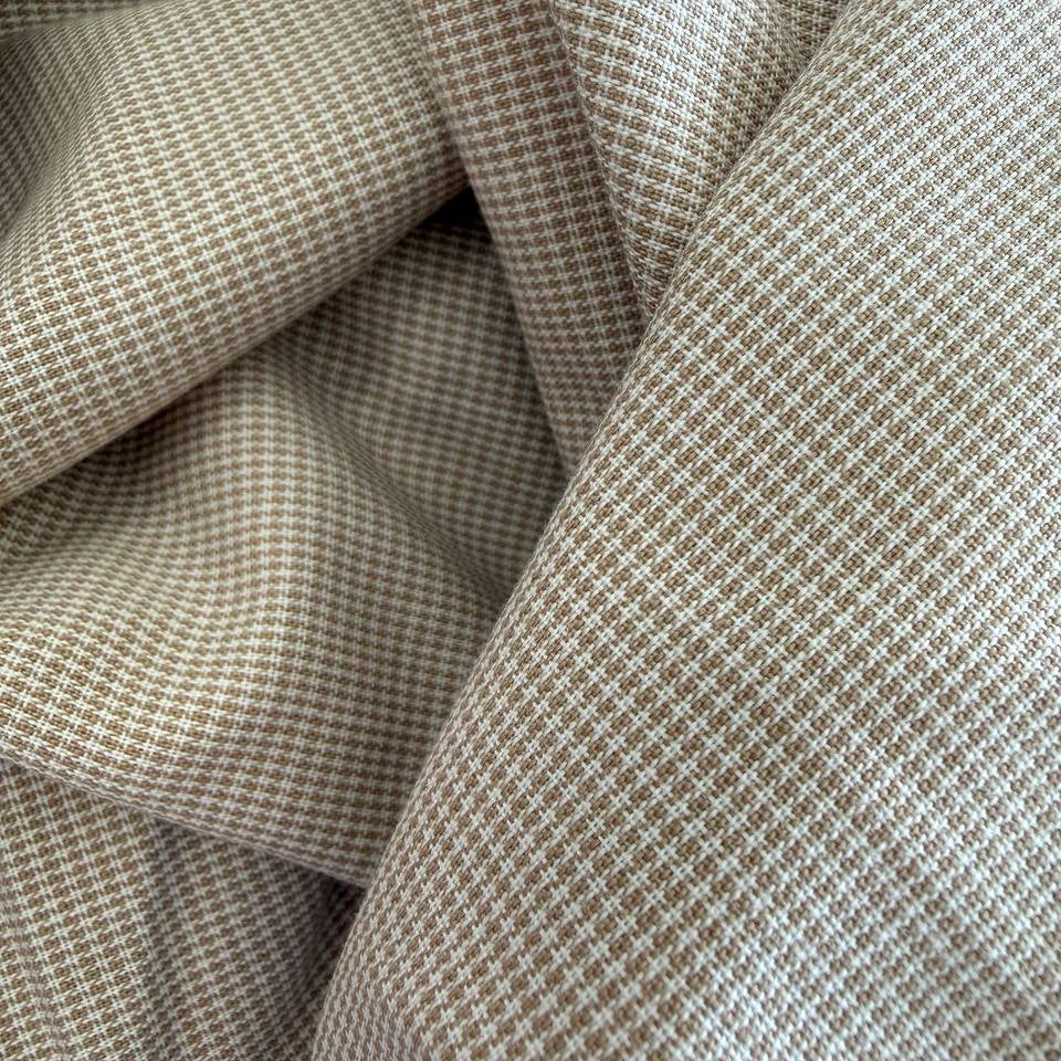 Soft and structured suiting fabric in a refined beige micro-check pattern.