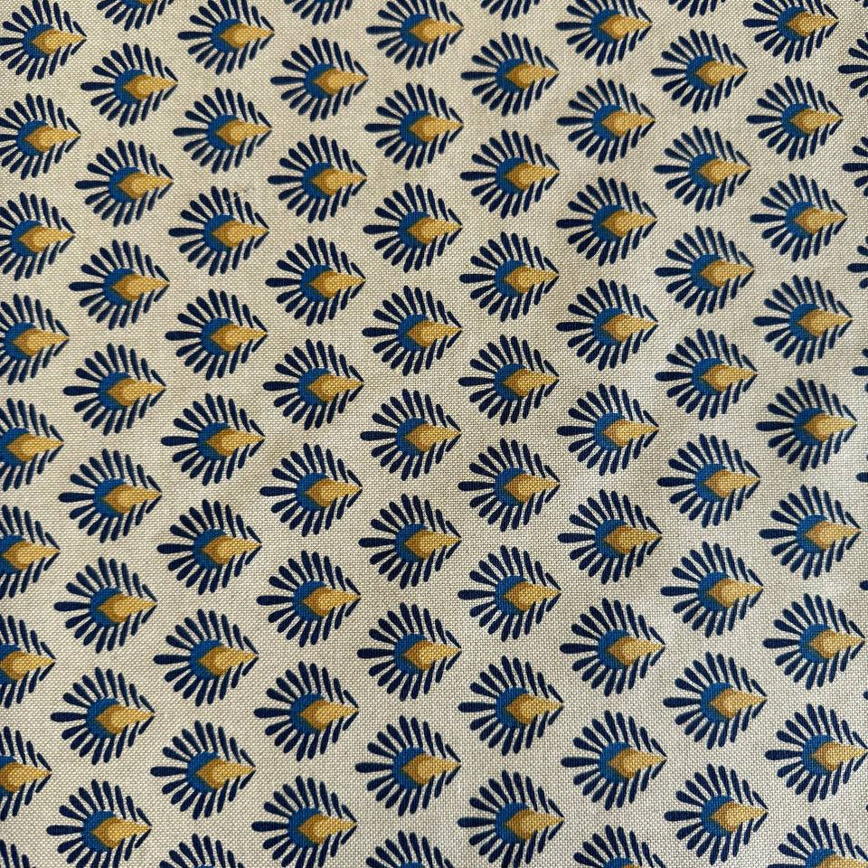 Beautiful 100% cotton home décor fabric with a structured weave and decorative botanical pattern in deep blue and warm mustard tones on a natural background.