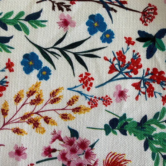 This cotton fabric features a delicate floral and botanical print on a light background.