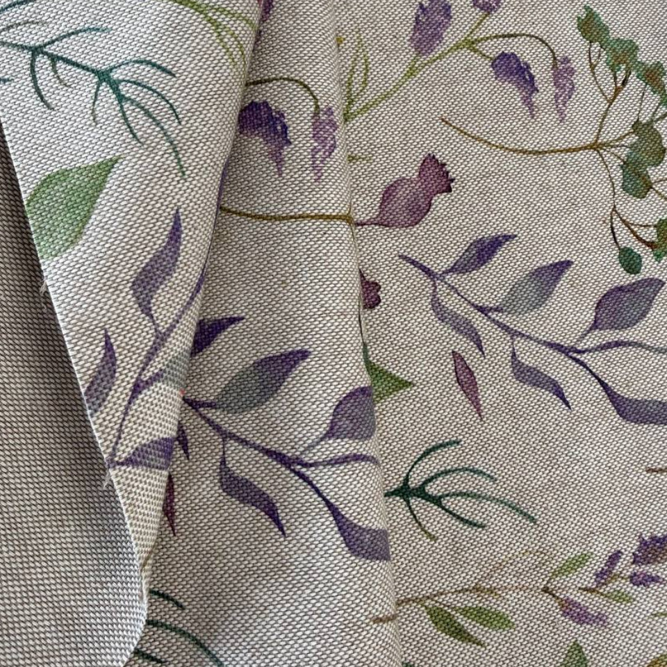 Decorative home décor fabric featuring a soft floral print in purple and green tones on a natural base.
