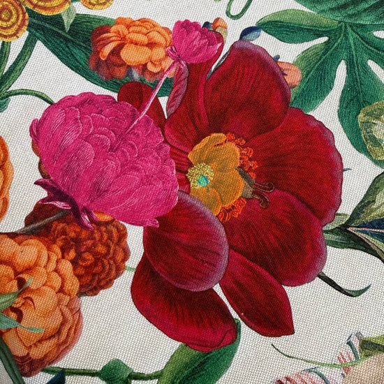 Beautiful botanical home décor fabric featuring an abundant floral garden print with vibrant flowers and lush green foliage on a soft ivory background