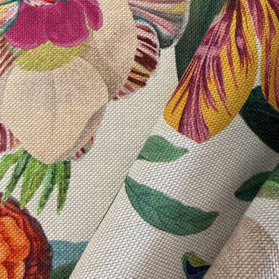 Beautiful botanical home décor fabric featuring an abundant floral garden print with vibrant flowers and lush green foliage on a soft ivory background