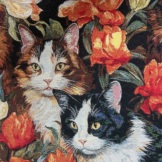 Beautiful tapestry home décor fabric featuring playful cats surrounded by vibrant orange and cream flowers on a dark background.