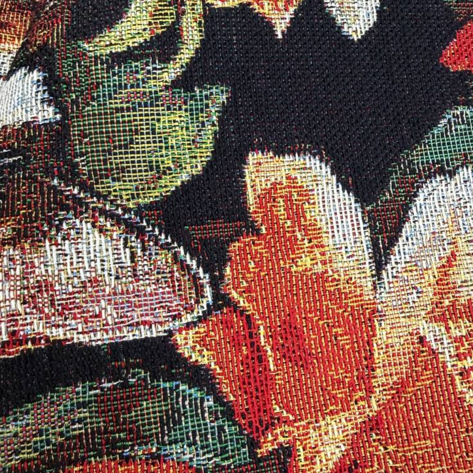 Beautiful tapestry home décor fabric featuring playful cats surrounded by vibrant orange and cream flowers on a dark background.