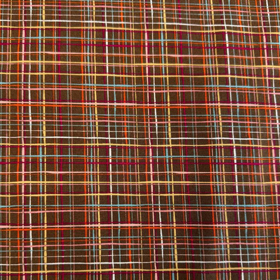 Brown quilting cotton featuring an intricate woven line plaid design in cocoa, orange, pink, blue, gold, and cream from the Things Above collection by Moda Fabrics.