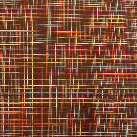 Brown quilting cotton featuring an intricate woven line plaid design in cocoa, orange, pink, blue, gold, and cream from the Things Above collection by Moda Fabrics.