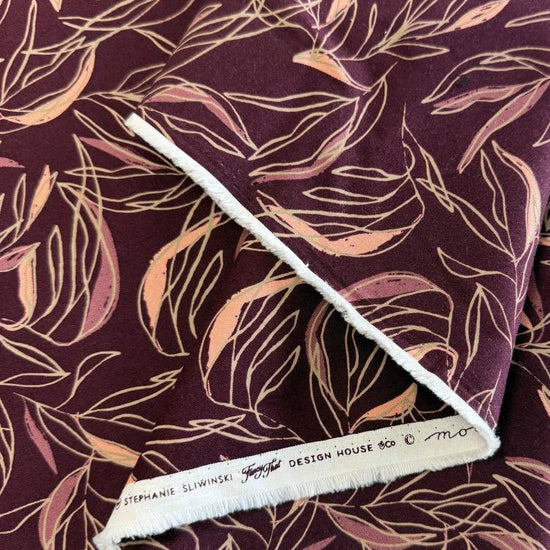 Deep plum quilting cotton featuring delicate scattered leaf silhouettes in mauve and blush tones from the Foraged, Found & Hand Me Down collection by Fancy That Design House for Moda Fabrics.