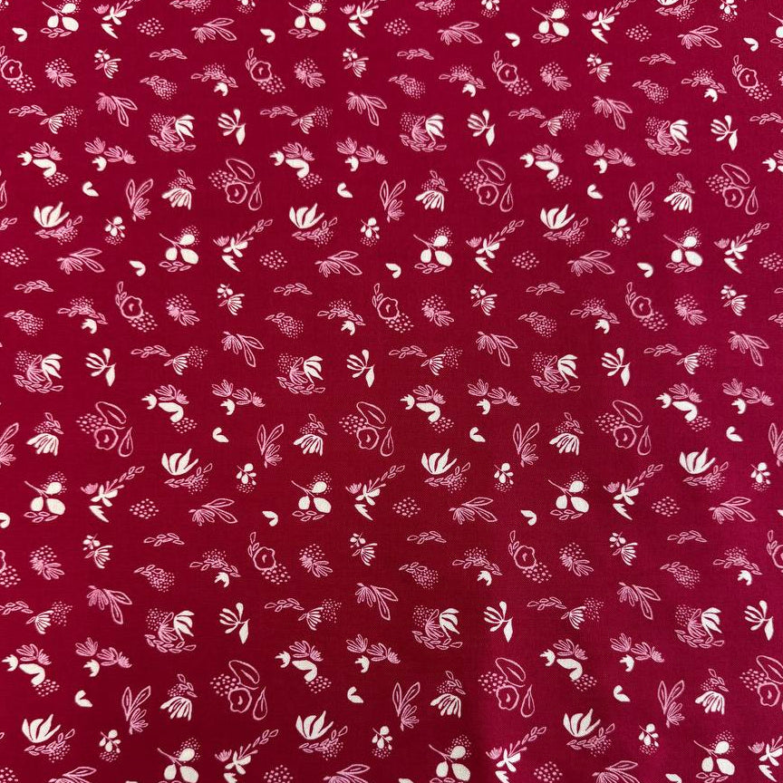 Crimson quilting cotton fabric featuring scattered cream and pink floral motifs from the Things Above collection by Stephanie Sliwinski for Moda Fabrics.