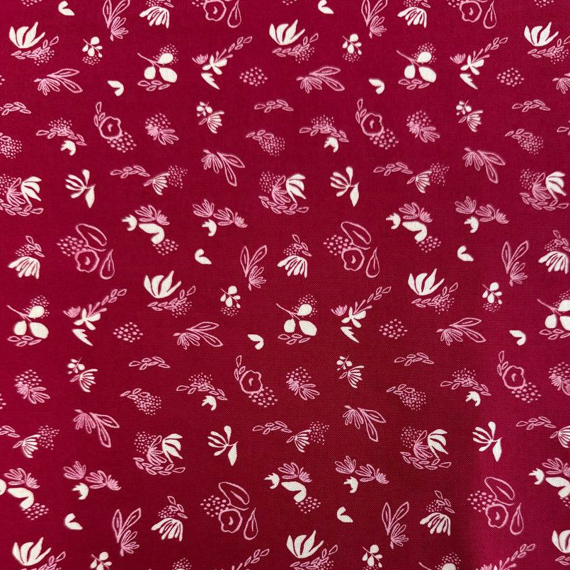 Crimson quilting cotton fabric featuring scattered cream and pink floral motifs from the Things Above collection by Stephanie Sliwinski for Moda Fabrics.