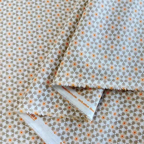 Small white floral lattice print with orange flower centers on a soft taupe smoke background from Agatha Road by Fig Tree & Co. for Moda.