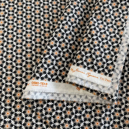 Small white floral lattice print with orange flower centers on a deep midnight background from Agatha Road by Fig Tree & Co. for Moda.