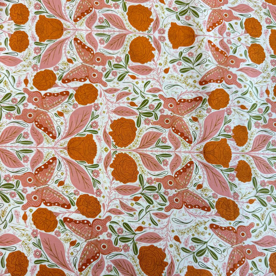 Woodland Wonder quilting cotton featuring pink butterflies, orange roses, soft pink leaves, and botanical motifs on a light cream background.
