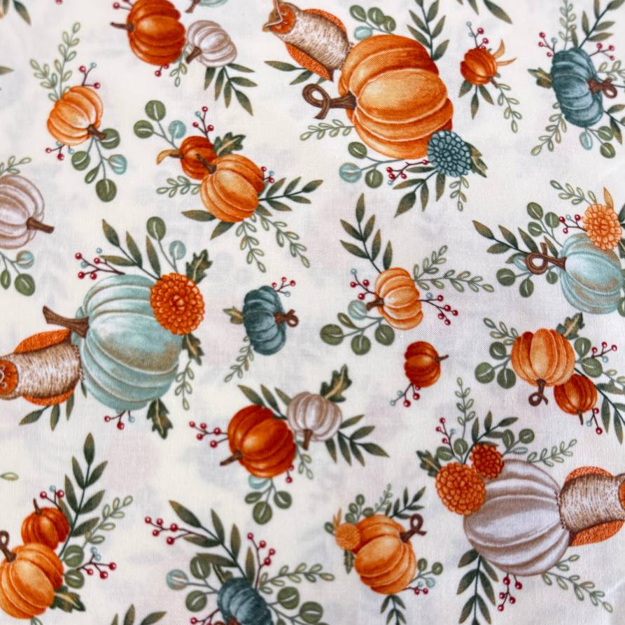 Autumn-themed quilting cotton featuring watercolor pumpkins, woodland elements, green foliage, and harvest florals on a light cream background from the I Love Fall Most Of All collection by Deb Strain for Moda Fabrics.