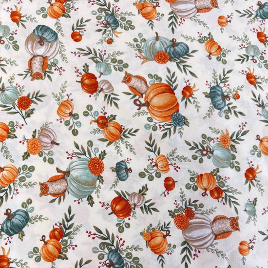 Autumn-themed quilting cotton featuring watercolor pumpkins, woodland elements, green foliage, and harvest florals on a light cream background from the I Love Fall Most Of All collection by Deb Strain for Moda Fabrics.