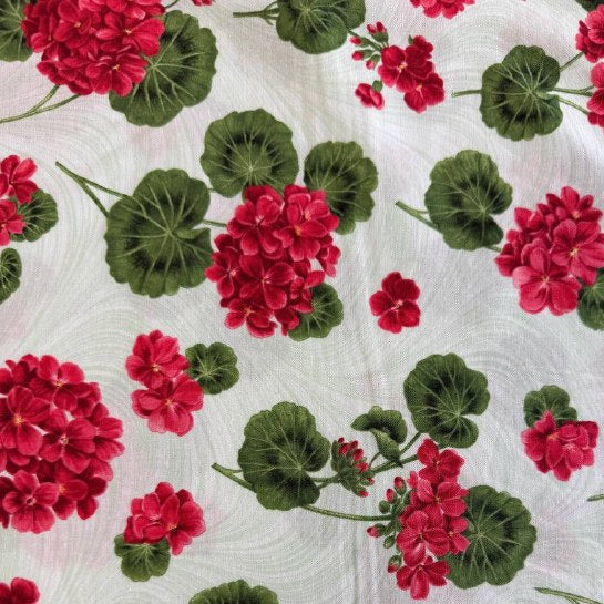 Red geranium flowers and green leaves scattered across a soft mint background quilting cotton fabric from Betty's Geraniums by Jackie Robinson for Benartex.