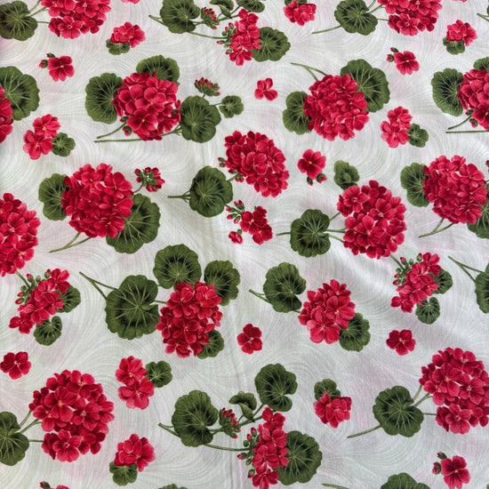 Red geranium flowers and green leaves scattered across a soft mint background quilting cotton fabric from Betty's Geraniums by Jackie Robinson for Benartex.