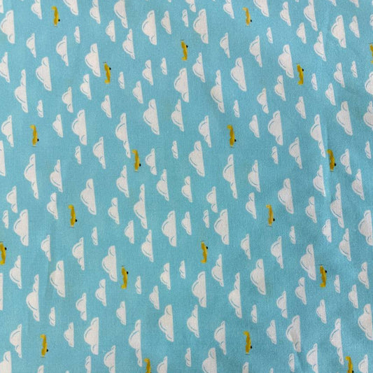 Light sky-blue quilting cotton featuring white clouds and small golden airplanes from the Aviation Adventures collection by Michael Miller.