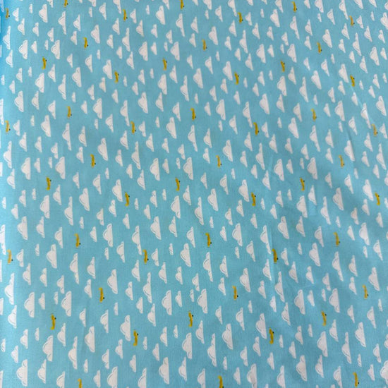 Light sky-blue quilting cotton featuring white clouds and small golden airplanes from the Aviation Adventures collection by Michael Miller.