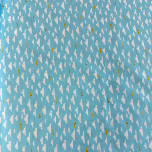 Light sky-blue quilting cotton featuring white clouds and small golden airplanes from the Aviation Adventures collection by Michael Miller.