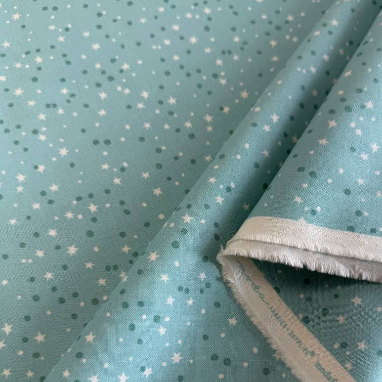 Blue quilting cotton featuring tiny white stars and scattered dots from the Blast Off collection by Stacy Iest Hsu for Moda Fabrics.