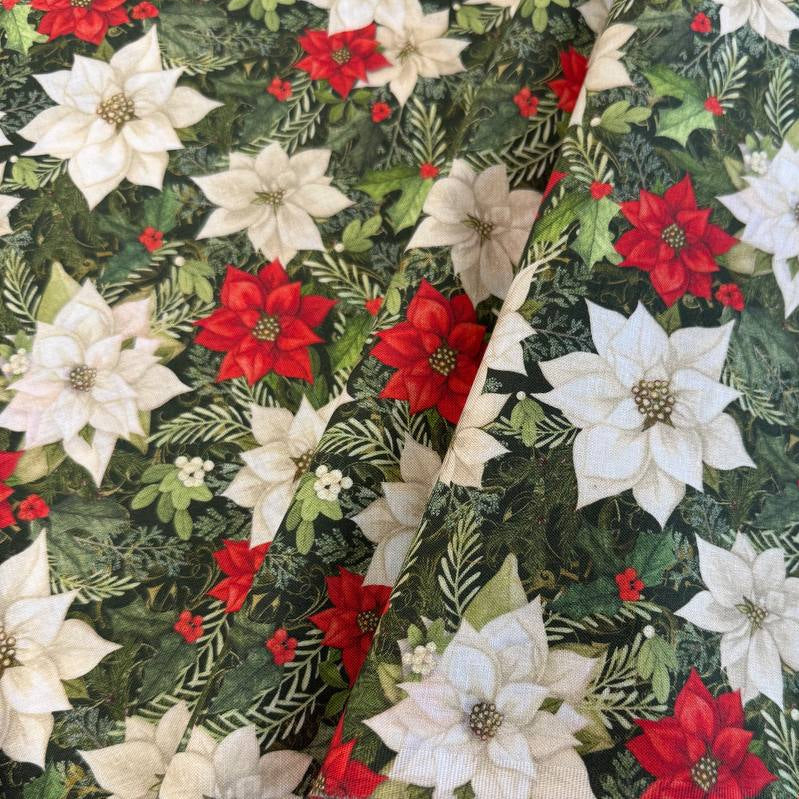 Christmas Poinsettia cotton fabric featuring red and white poinsettia flowers with green foliage on a dark green background.