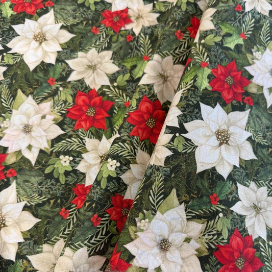 Christmas Poinsettia cotton fabric featuring red and white poinsettia flowers with green foliage on a dark green background.