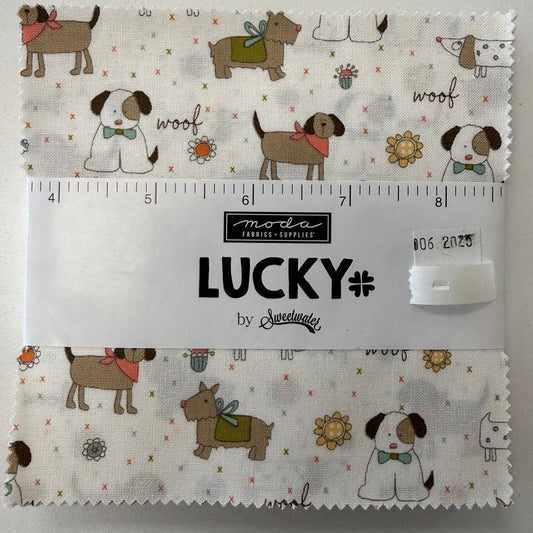 Lucky charm pack fabric bundle by Sweetwater for Moda Fabrics with 42 precut 5 inch cotton quilting squares featuring cute dogs on cream background