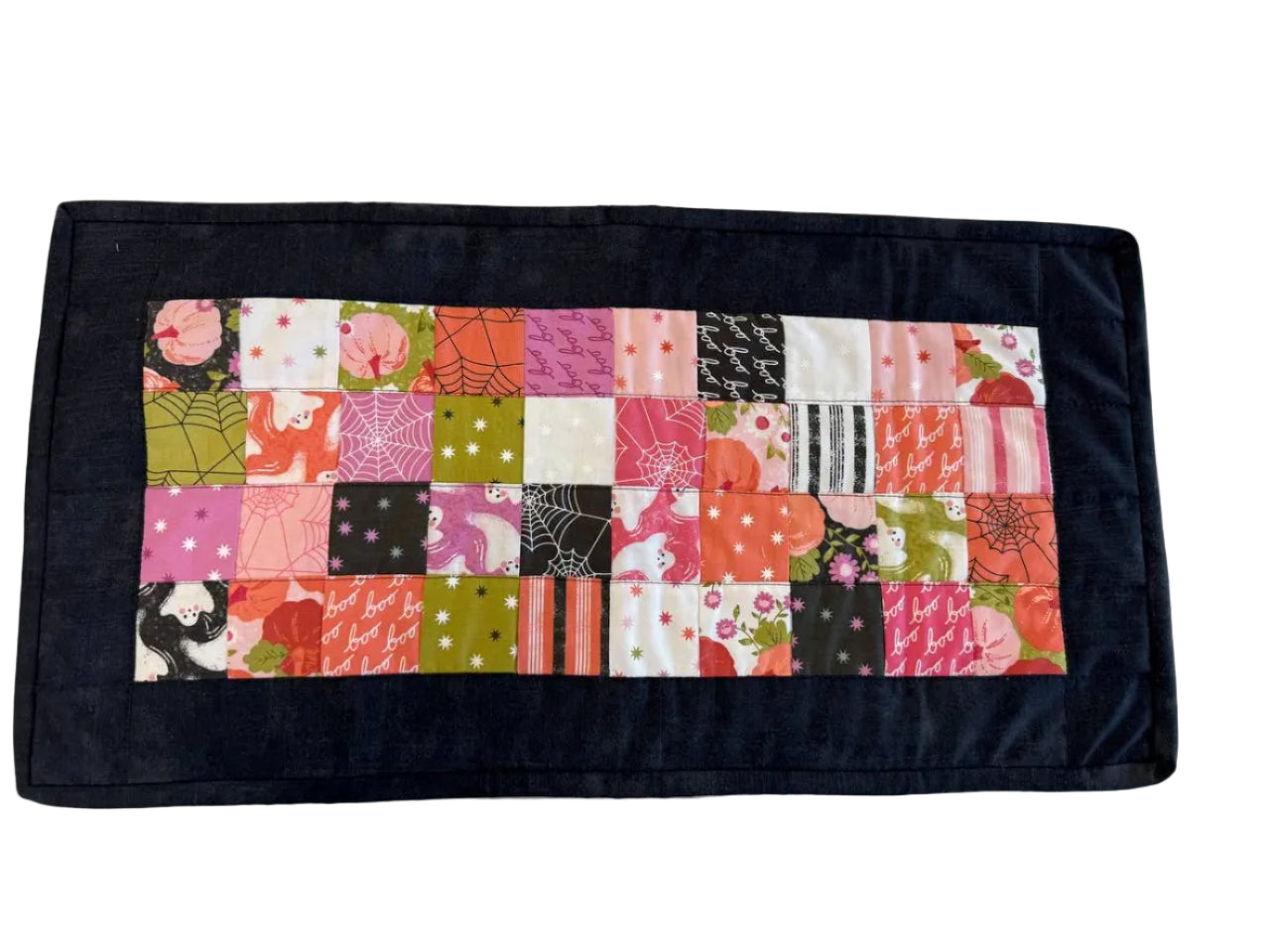 Mini Charm Hey Boo Table Runner Kit including Halloween-themed mini charm pack, coordinating black and pink fabrics, and batting for a festive quilted table runner.