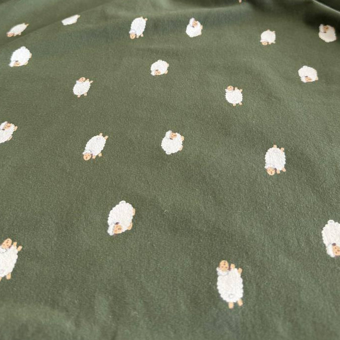 Olive green cotton jersey fabric with small sheep print knit stretch fabric