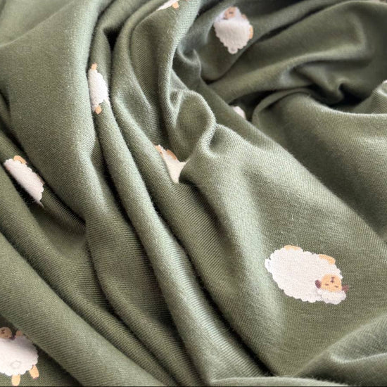 Olive green cotton jersey fabric with small sheep print knit stretch fabric