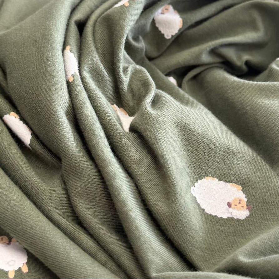 Olive green cotton jersey fabric with small sheep print knit stretch fabric