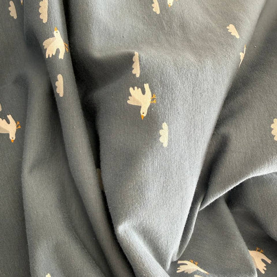 Blue grey cotton jersey fabric with small white bird print stretch knit fabric
