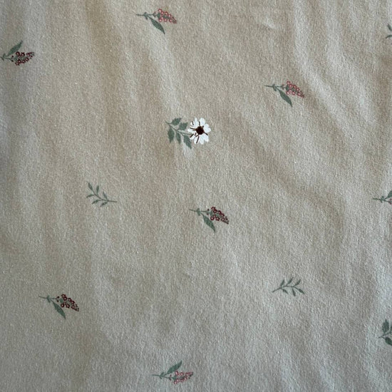 Beige cotton jersey fabric with small scattered floral print