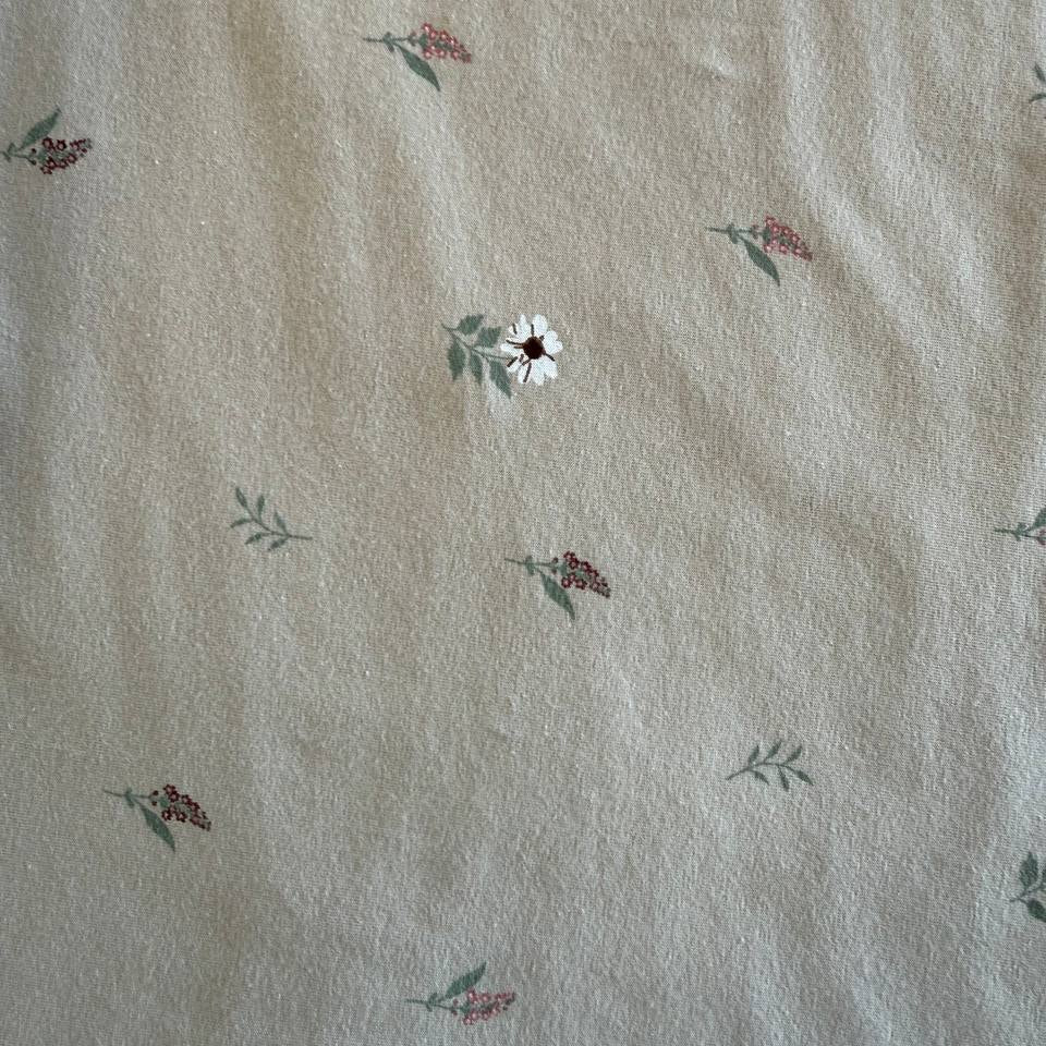 Beige cotton jersey fabric with small scattered floral print