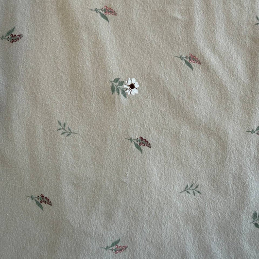 Beige cotton jersey fabric with small scattered floral print